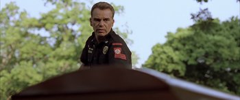 Movie still from “Monster's Ball” (2001), directed by Marc Forster – A man in a police uniform is standing in front of a tree; Close Up shot, Low angle