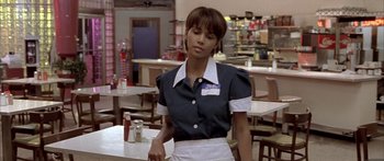 Movie still from “Monster's Ball” (2001), directed by Marc Forster – A woman standing in front of a table in a restaurant; Medium shot, Over the shoulder angle
