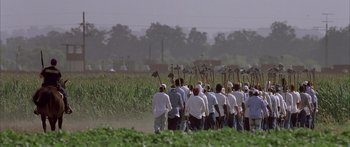 Movie still from “Monster's Ball” (2001), directed by Marc Forster – A group of people walking through a field with shovels; Extreme Wide shot, High angle