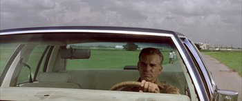 Movie still from “Monster's Ball” (2001), directed by Marc Forster – A man driving a car in a rural area; Medium shot, Low angle
