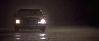 Movie still from “Monster's Ball” (2001), directed by Marc Forster – A car driving down a wet road at night; Wide shot, Low angle