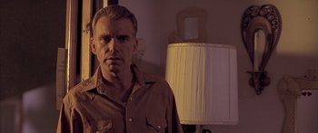 Movie still from “Monster's Ball” (2001), directed by Marc Forster – A man standing in front of a lamp in a room; Close Up shot, Low angle