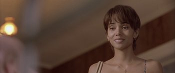 Movie still from “Monster's Ball” (2001), directed by Marc Forster – A woman with short brown hair is smiling for the camera; Close Up shot, Over the shoulder angle
