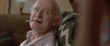 Movie still from “Monster's Ball” (2001), directed by Marc Forster – An older man sitting on a chair with a cigarette in his mouth; Close Up shot, Over the shoulder angle