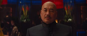 Movie still from “Mortdecai” (2015), directed by David Koepp – A man with a bald head wearing a black suit; Close Up shot, Low angle