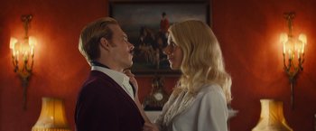 Movie still from “Mortdecai” (2015), directed by David Koepp – A man and a woman standing next to each other in a room; Medium shot, Low angle