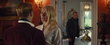 Movie still from “Mortdecai” (2015), directed by David Koepp – A woman standing next to a man in front of a mirror; Medium shot, Over the shoulder angle