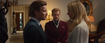 Movie still from “Mortdecai” (2015), directed by David Koepp – Two men and a woman standing next to each other in a room; Medium shot, Over the shoulder angle