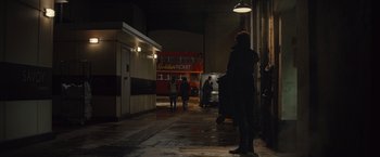 Movie still from “Mortdecai” (2015), directed by David Koepp – A red double decker bus parked in a dark alley; Wide shot, Low angle