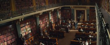 Movie still from “Mortdecai” (2015), directed by David Koepp – A library filled with lots of books and people; Extreme Wide shot, High angle