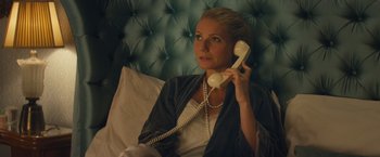 Movie still from “Mortdecai” (2015), directed by David Koepp – A woman sitting on a bed holding a phone to her ear; Close Up shot, High angle