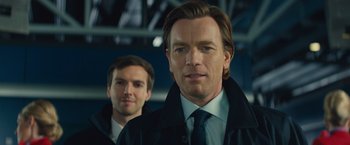 Movie still from “Mortdecai” (2015), directed by David Koepp – A man in a suit and tie standing next to another man in a suit and tie; Close Up shot, Low angle