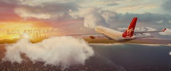 Movie still from “Mortdecai” (2015), directed by David Koepp – An airplane flying over a body of water; Extreme Wide shot, Low angle