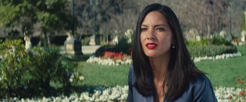 Movie still from “Mortdecai” (2015), directed by David Koepp – A woman with red lipstick sitting in front of a flower garden; Close Up shot, Over the shoulder angle
