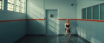 Movie still from “Mortdecai” (2015), directed by David Koepp – A woman sitting on a chair next to a door; Wide shot, Low angle