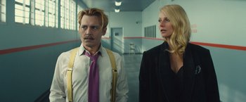 Movie still from “Mortdecai” (2015), directed by David Koepp – A man and a woman standing next to each other in a room; Medium shot, Low angle