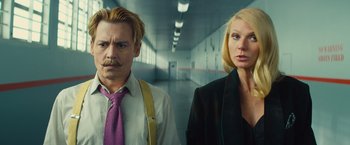 Movie still from “Mortdecai” (2015), directed by David Koepp – A man and a woman standing next to each other in a hallway; Close Up shot, Low angle