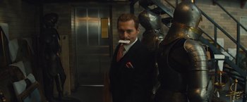 Movie still from “Mortdecai” (2015), directed by David Koepp – A man in a suit and tie holding a toothbrush in his mouth; Close Up shot, Low angle