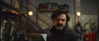 Movie still from “Mortdecai” (2015), directed by David Koepp – A man with a mustache standing in a room; Close Up shot, Over the shoulder angle