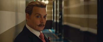 Movie still from “Mortdecai” (2015), directed by David Koepp – A man in a suit and tie with a goatee; Close Up shot, Low angle