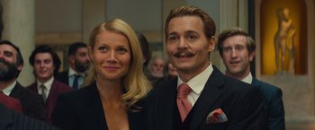 Movie still from “Mortdecai” (2015), directed by David Koepp – A man and a woman standing next to each other; Close Up shot, Low angle