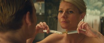 Movie still from “Mortdecai” (2015), directed by David Koepp – A woman holding a toothbrush in front of a mirror; Close Up shot, Over the shoulder angle