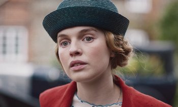 Movie still from “Mothering Sunday” (2021), directed by Eva Husson – A person wearing a hat; Close Up shot, Low angle