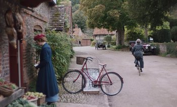 Movie still from “Mothering Sunday” (2021), directed by Eva Husson – An old fashioned bicycle parked on the side of the road; Extreme Wide shot, High angle
