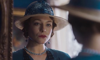 Movie still from “Mothering Sunday” (2021), directed by Eva Husson – A woman wearing a hat and a necklace; Close Up shot, Over the shoulder angle