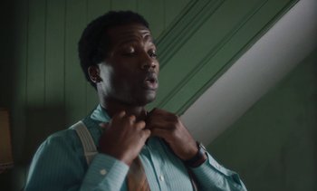 Movie still from “Mothering Sunday” (2021), directed by Eva Husson – A man adjusts his neck tie while looking up; Close Up shot, Low angle