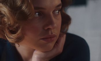 Movie still from “Mothering Sunday” (2021), directed by Eva Husson – A woman's face with her hand under her chin; Close Up shot, Over the shoulder angle