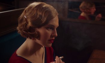 Movie still from “Mothering Sunday” (2021), directed by Eva Husson – A woman smoking a cigarette in front of a mirror; Close Up shot, Over the shoulder angle