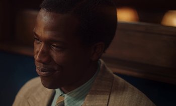 Movie still from “Mothering Sunday” (2021), directed by Eva Husson – A person wearing a suit and tie; Close Up shot, Over the shoulder angle