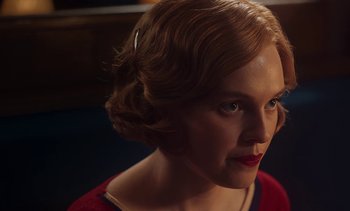 Movie still from “Mothering Sunday” (2021), directed by Eva Husson – A person wearing a red dress; Close Up shot, Over the shoulder angle