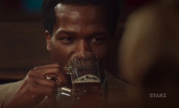 Movie still from “Mothering Sunday” (2021), directed by Eva Husson – A person drinking a glass of beer; Close Up shot, Over the shoulder angle