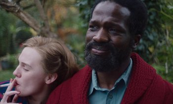 Movie still from “Mothering Sunday” (2021), directed by Eva Husson – A person with a beard wearing a sweater; Close Up shot, Over the shoulder angle