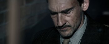 Movie still from “Mr. Jones” (2019), directed by Agnieszka Holland – A person wearing a suit and tie; Close Up shot, High angle