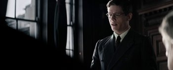 Movie still from “Mr. Jones” (2019), directed by Agnieszka Holland – A man in a suit and tie standing in front of a window; Close Up shot, Low angle