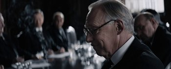 Movie still from “Mr. Jones” (2019), directed by Agnieszka Holland – A man in a suit and tie looking to his left; Close Up shot, Over the shoulder angle