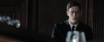 Movie still from “Mr. Jones” (2019), directed by Agnieszka Holland – A man sitting in front of a wooden wall; Close Up shot, Over the shoulder angle