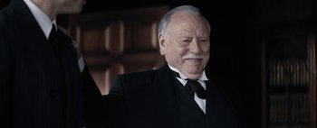 Movie still from “Mr. Jones” (2019), directed by Agnieszka Holland – An older man wearing a suit and a tie; Close Up shot, Low angle