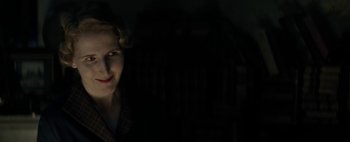 Movie still from “Mr. Jones” (2019), directed by Agnieszka Holland – A woman with red lipstick is smiling in the dark; Close Up shot, Low angle