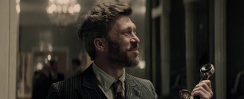 Movie still from “Mr. Jones” (2019), directed by Agnieszka Holland – A man in a suit and tie looking to his left; Close Up shot, Over the shoulder angle