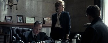 Movie still from “Mr. Jones” (2019), directed by Agnieszka Holland – A man and a woman sitting at a table; Medium shot, Low angle