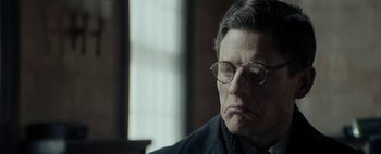 Movie still from “Mr. Jones” (2019), directed by Agnieszka Holland – An older man wearing glasses and a black jacket; Close Up shot, Low angle