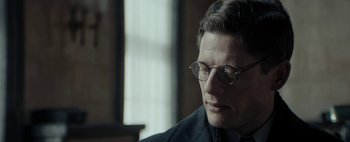 Movie still from “Mr. Jones” (2019), directed by Agnieszka Holland – A person wearing a suit and glasses; Close Up shot, Over the shoulder angle