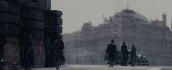 Movie still from “Mr. Jones” (2019), directed by Agnieszka Holland – Two people walking down a street in the rain; Wide shot, Low angle