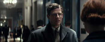 Movie still from “Mr. Jones” (2019), directed by Agnieszka Holland – A man in a suit and tie standing next to a building; Close Up shot, Low angle