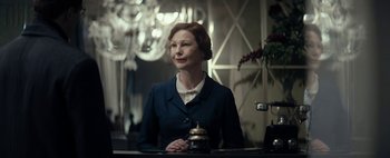 Movie still from “Mr. Jones” (2019), directed by Agnieszka Holland – A woman standing at a counter in front of a bell; Medium shot, Low angle