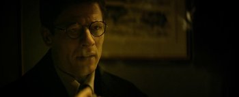 Movie still from “Mr. Jones” (2019), directed by Agnieszka Holland – A person wearing a suit and glasses; Close Up shot, Low angle